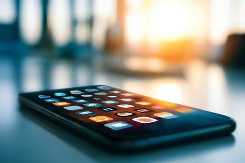 Smartphone lying face-up on a desk showing an unlocked home screen with app icons