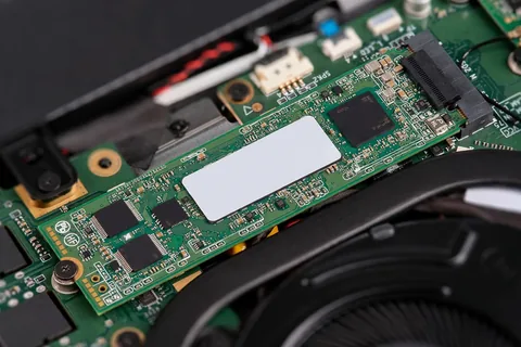 An M.2 NVMe SSD seated in a laptop motherboard slot and held by a single screw