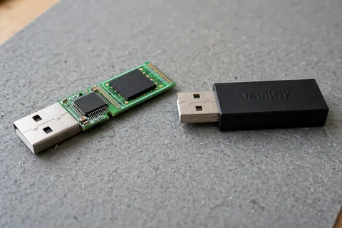A two-chip USB drive board beside a monolithic USB module that is one black block with a plug