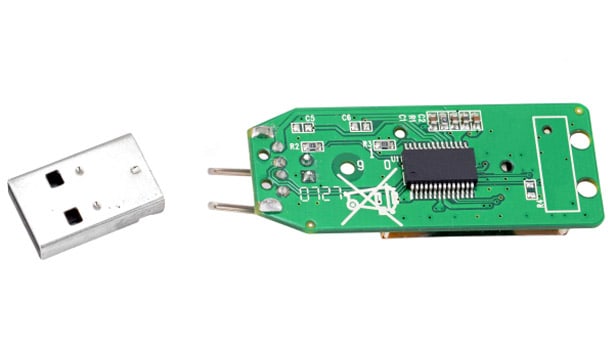 USB flash drive with its connector snapped off, exposing the green PCB and NAND flash chip recovered at eProvided
